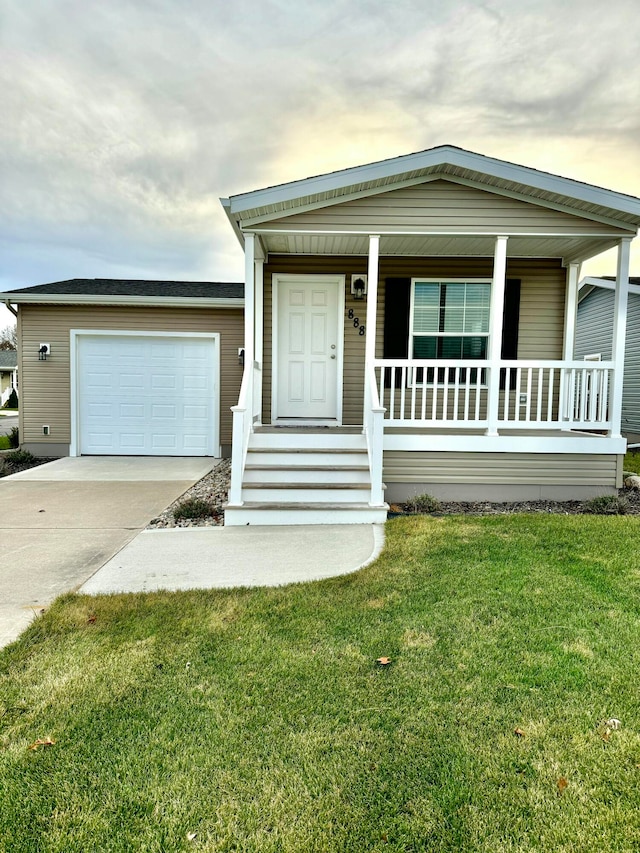 view of front of house with a lawn, a porch, and a garage