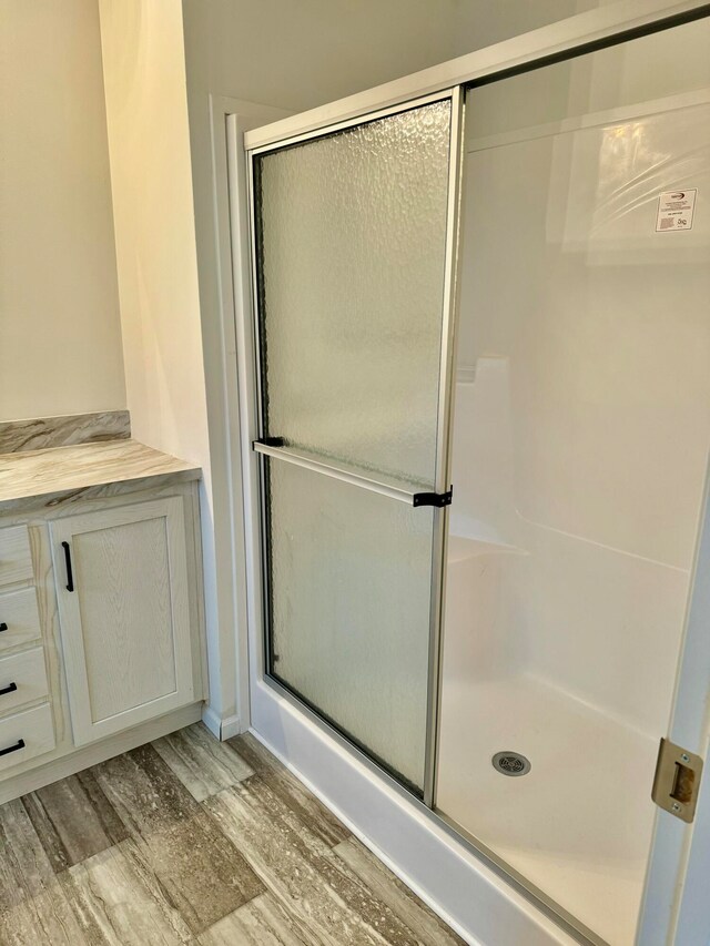 bathroom with hardwood / wood-style floors and a shower with door