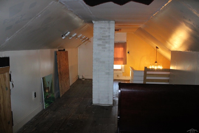 bonus room featuring a notable chandelier, dark hardwood / wood-style floors, and lofted ceiling