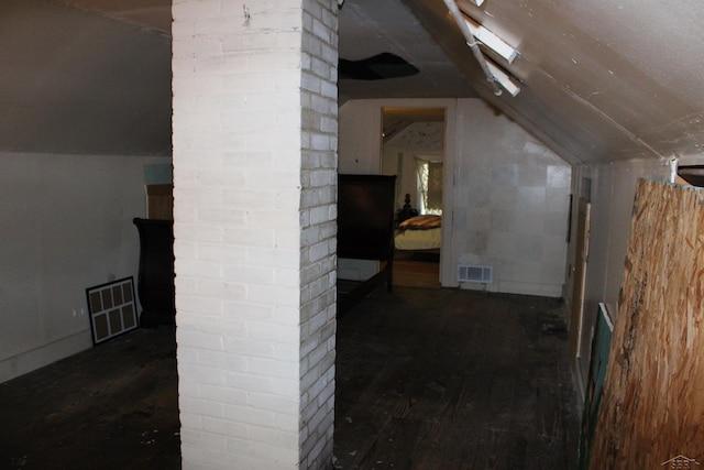 additional living space with dark hardwood / wood-style flooring and vaulted ceiling