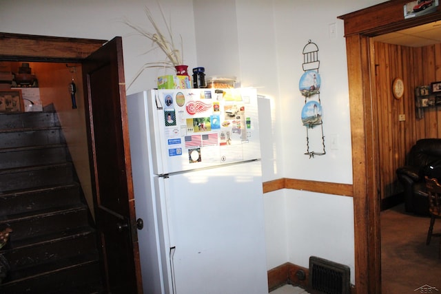 kitchen featuring wood walls and white refrigerator