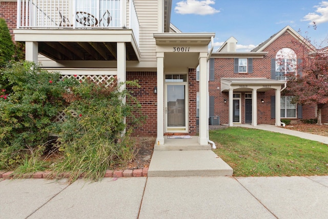 doorway to property with a yard and a balcony