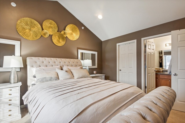 bedroom featuring light carpet, ensuite bathroom, and vaulted ceiling