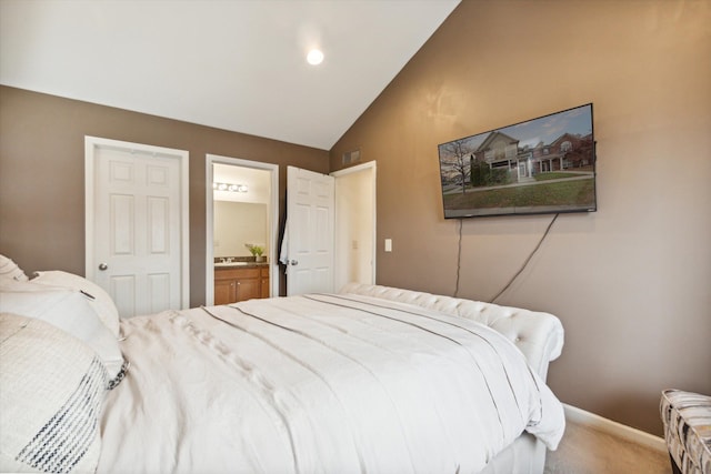 carpeted bedroom with lofted ceiling and connected bathroom