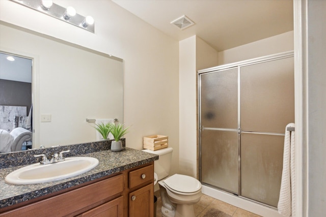 bathroom featuring toilet, vanity, tile patterned floors, and an enclosed shower