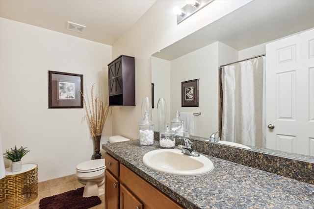 bathroom with tile patterned flooring, vanity, and toilet