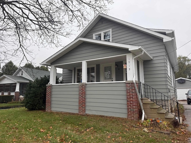 bungalow-style home with covered porch and a front lawn