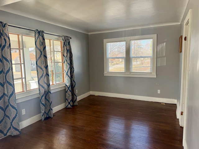 empty room with dark wood-type flooring and baseboards