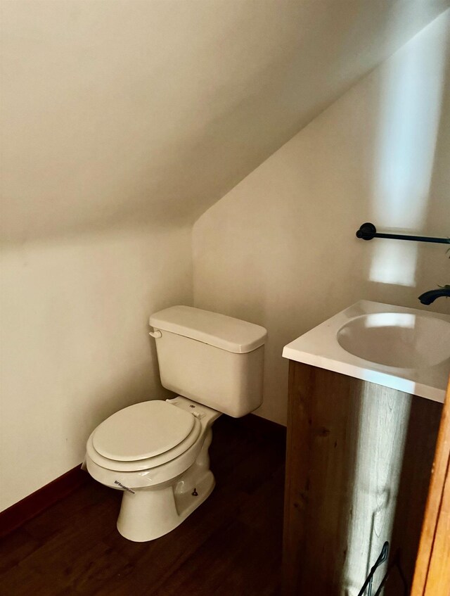 bathroom featuring vanity, vaulted ceiling, toilet, and wood finished floors