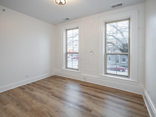 empty room with hardwood / wood-style flooring and a healthy amount of sunlight