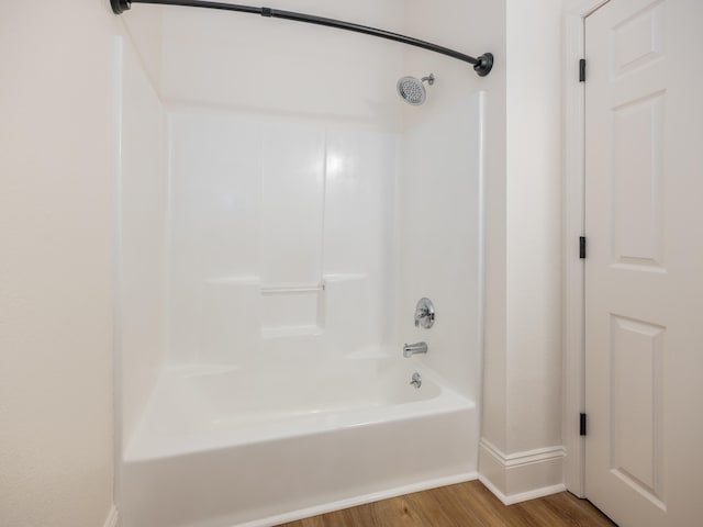 bathroom featuring hardwood / wood-style flooring and bathtub / shower combination