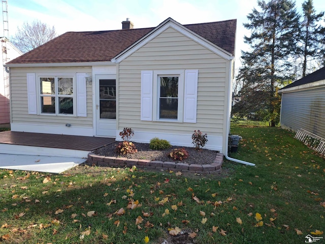 113 Walnut St, Brooklyn, MI 49230 - view of front of house with a wooden deck, a front yard, a shingled roof, and a chimney