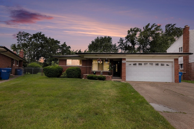 view of front of home with a yard and a garage