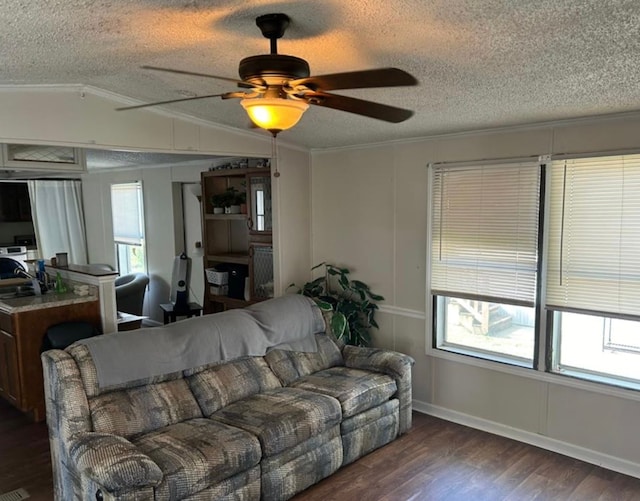 living room with ceiling fan, dark hardwood / wood-style flooring, crown molding, a textured ceiling, and vaulted ceiling