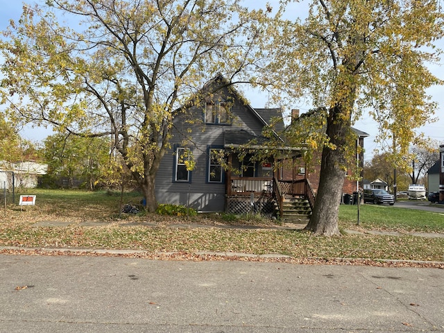 view of front of home featuring covered porch and a front lawn