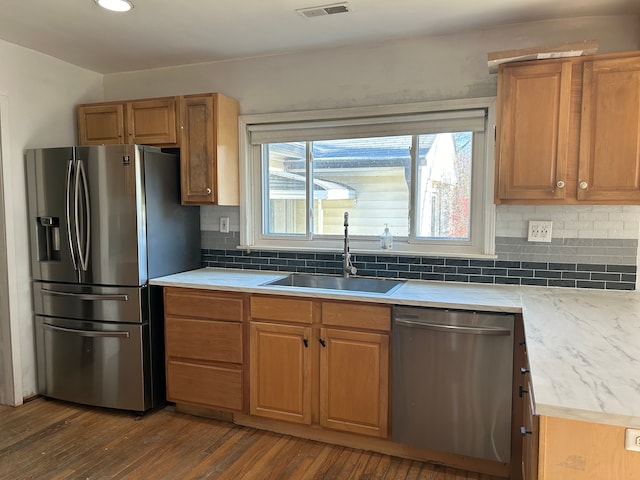 kitchen featuring dark hardwood / wood-style floors, sink, appliances with stainless steel finishes, and tasteful backsplash