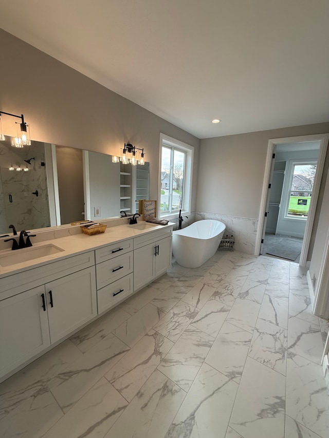 bathroom with vanity and shower with separate bathtub