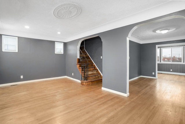 basement with a textured ceiling and light hardwood / wood-style flooring