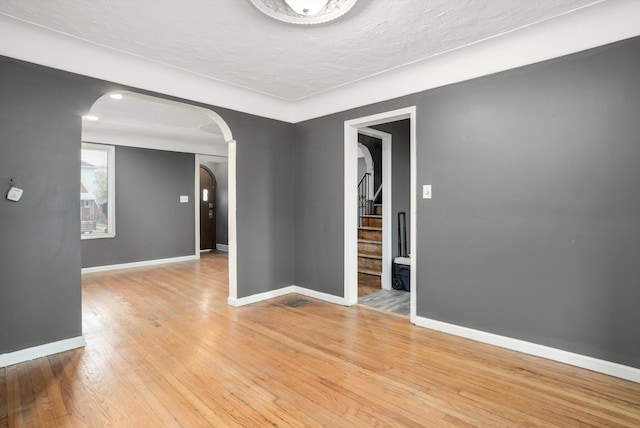 empty room featuring a textured ceiling and light wood-type flooring