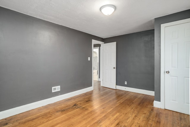 unfurnished bedroom with a textured ceiling and hardwood / wood-style flooring