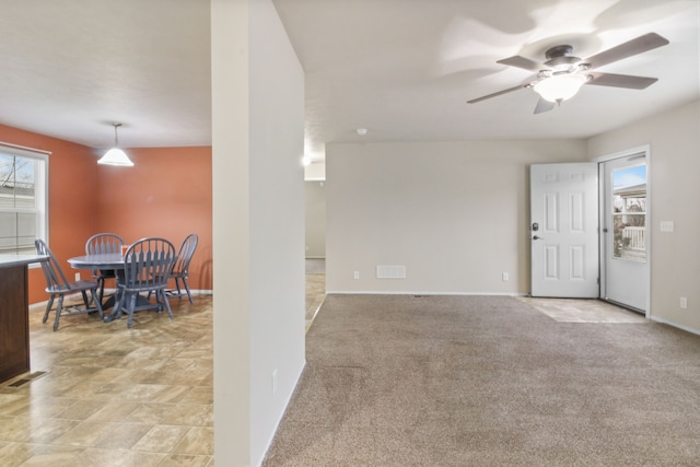 interior space featuring ceiling fan and light colored carpet