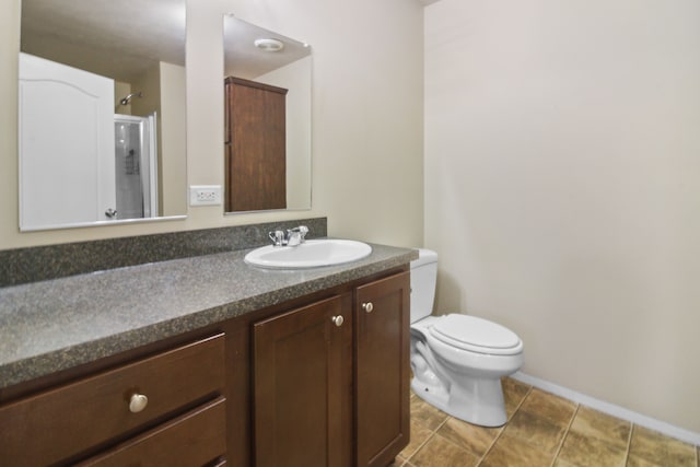 bathroom featuring vanity, toilet, and an enclosed shower