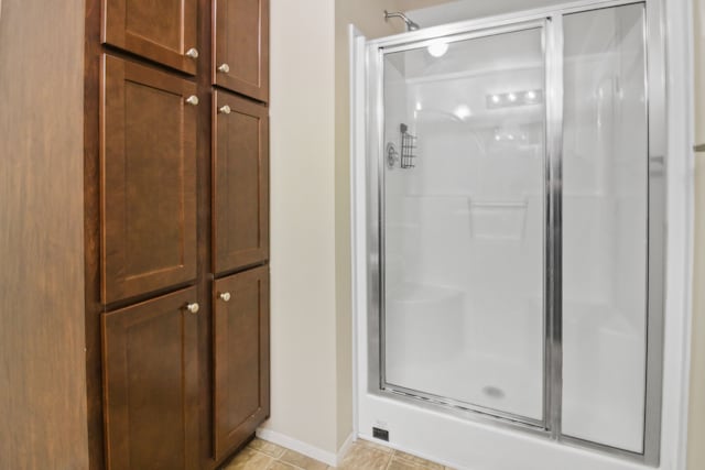 bathroom with tile patterned flooring and walk in shower