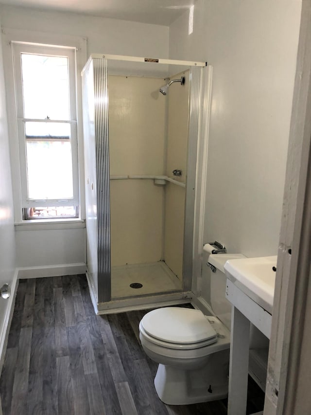 bathroom featuring walk in shower, toilet, and hardwood / wood-style flooring