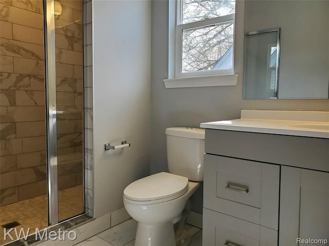 bathroom with an enclosed shower, vanity, and toilet