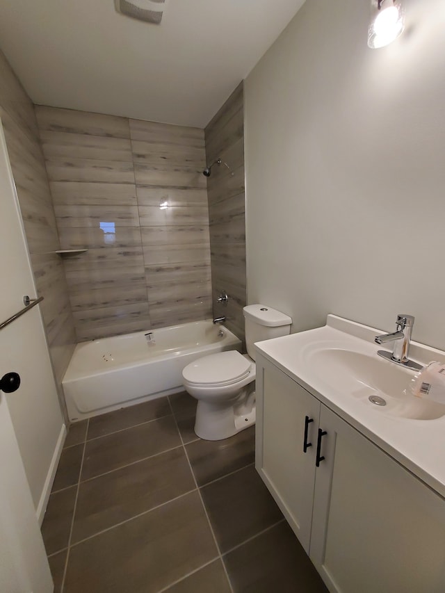 full bathroom with tile patterned flooring, vanity, tiled shower / bath combo, and toilet