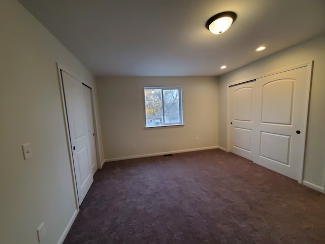 unfurnished bedroom featuring dark carpet