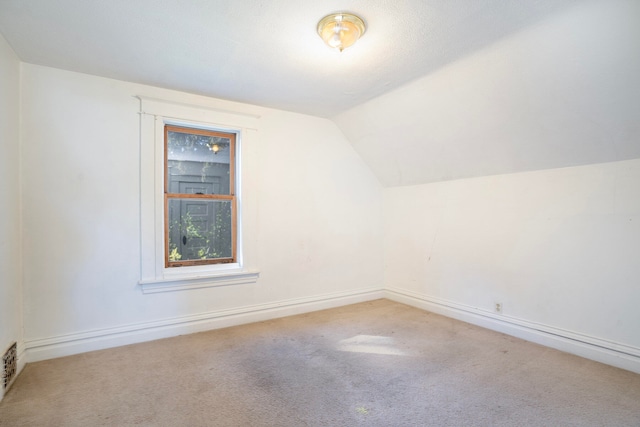 additional living space featuring carpet and vaulted ceiling