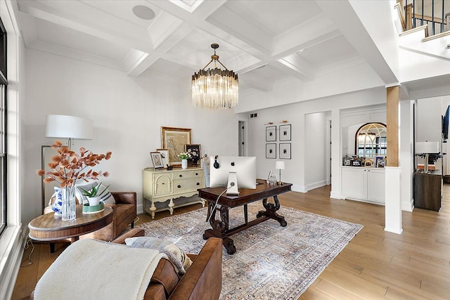 office area with beamed ceiling, a notable chandelier, a wealth of natural light, and light hardwood / wood-style flooring