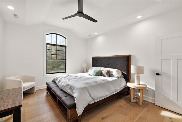 bedroom with ceiling fan, vaulted ceiling, and light hardwood / wood-style flooring