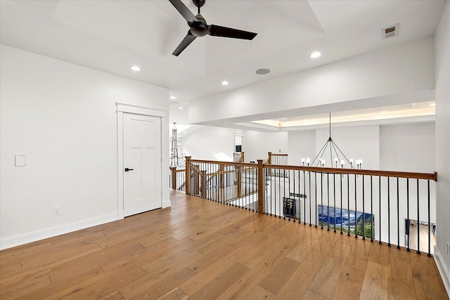 empty room featuring light hardwood / wood-style floors and ceiling fan with notable chandelier