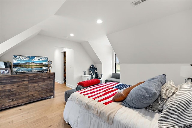 bedroom with light hardwood / wood-style floors and vaulted ceiling