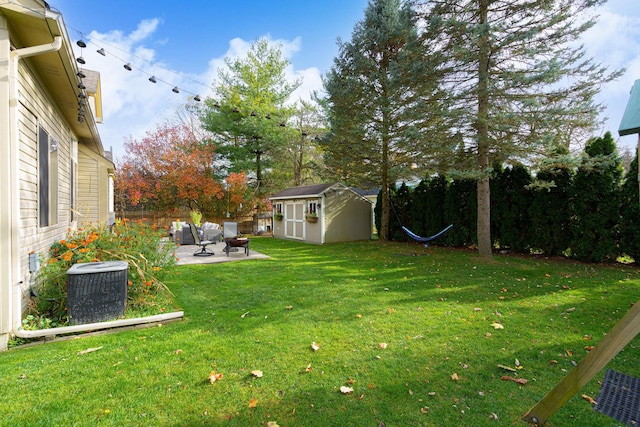 view of yard featuring a patio, central AC unit, and a storage unit