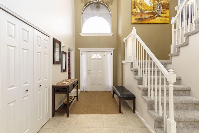 foyer featuring light tile patterned floors and a high ceiling