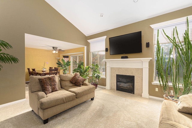 living room featuring a tile fireplace, light colored carpet, high vaulted ceiling, and ceiling fan