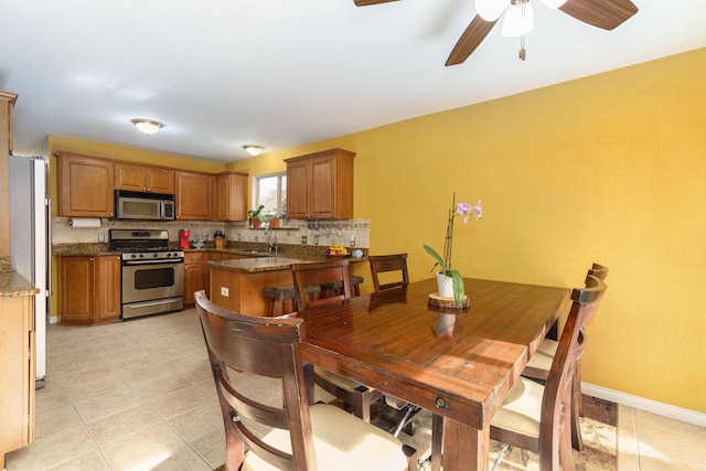 tiled dining space with ceiling fan and sink