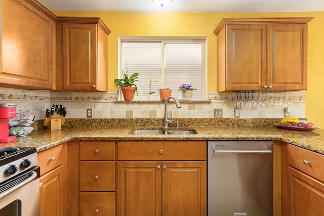 kitchen featuring decorative backsplash, appliances with stainless steel finishes, light stone counters, and sink