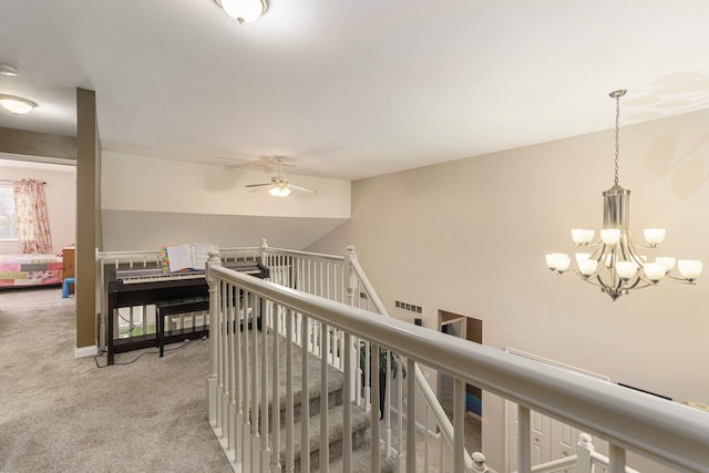 hallway featuring light carpet and an inviting chandelier