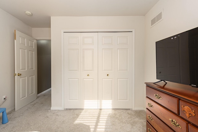 unfurnished bedroom featuring light colored carpet and a closet