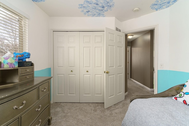 bedroom featuring light carpet and a closet