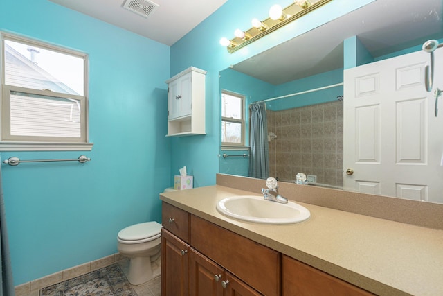 bathroom with walk in shower, vanity, and toilet