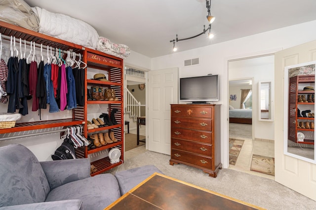 walk in closet featuring light colored carpet