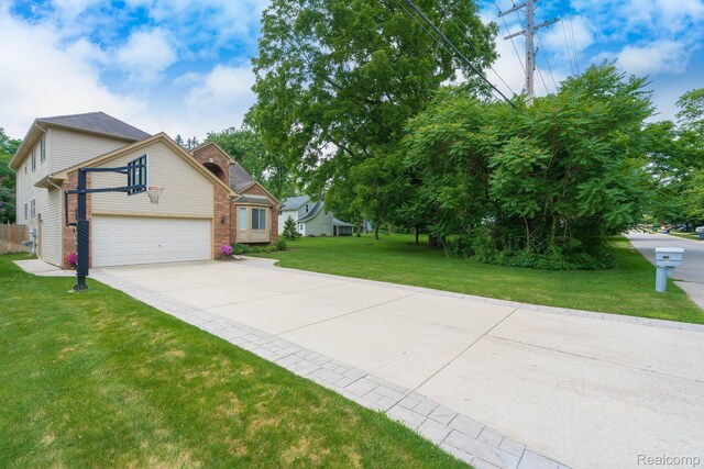 230 E Elizabeth St, Lake Orion, MI 48362 - view of front of house featuring concrete driveway, a garage, and a front yard