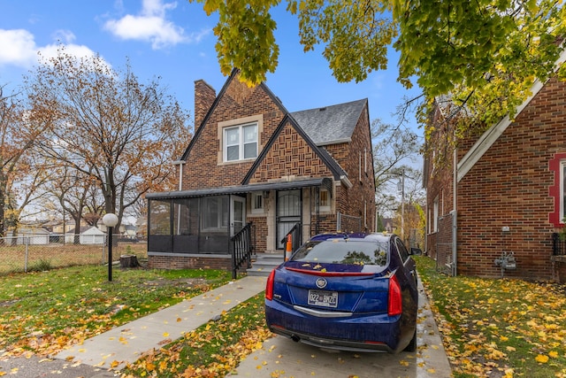 view of front of home with a front lawn and a sunroom