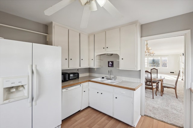 kitchen with white appliances, light hardwood / wood-style floors, white cabinetry, and sink