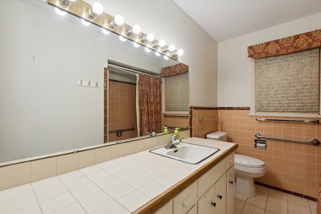 bathroom with tile patterned flooring, vanity, toilet, and tile walls